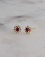 Gold flower stud earrings with ruby stone.