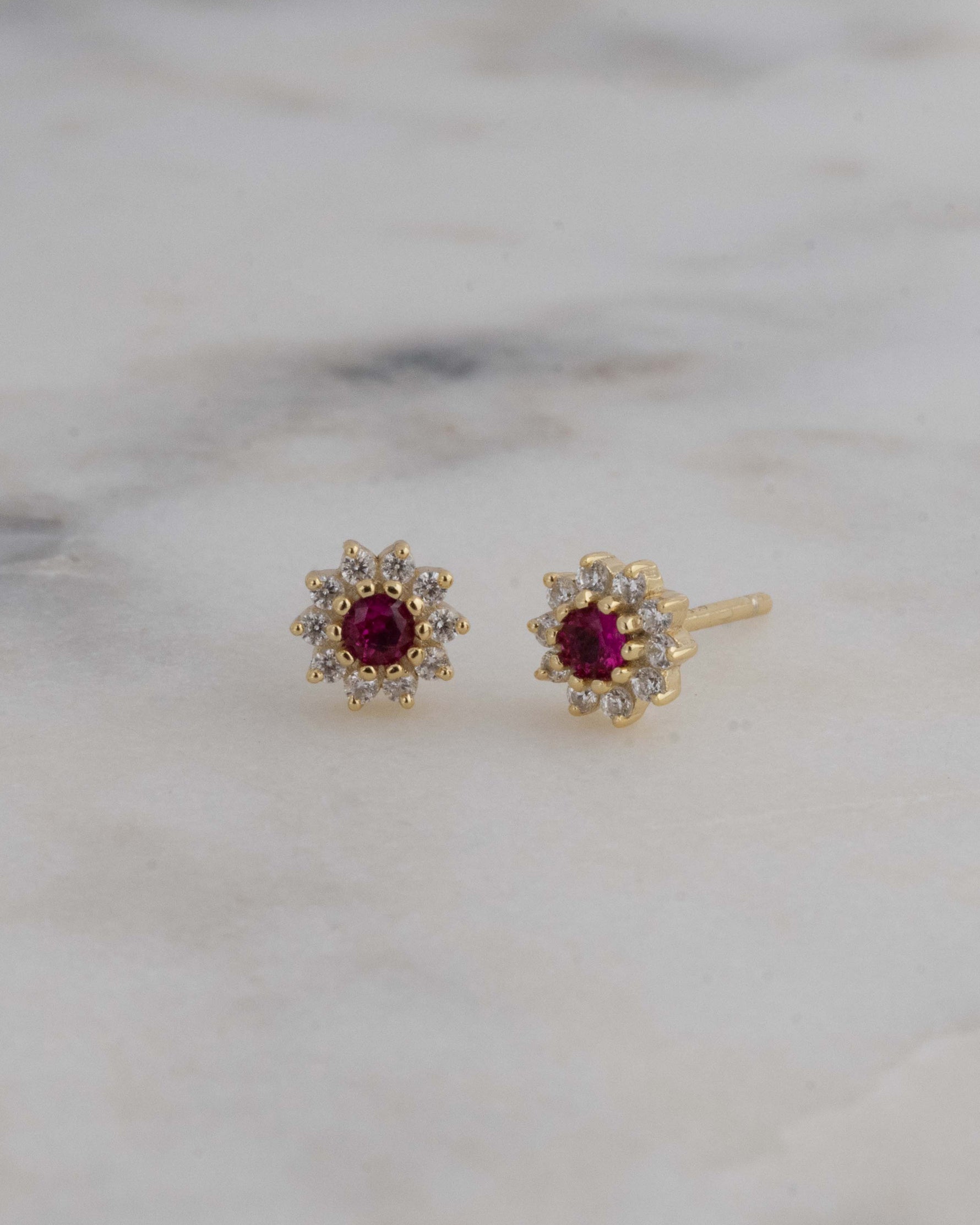 Gold flower stud earrings with ruby stone.
