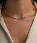 Gold Ruby Bezel Tennis Necklace by Sami Jewels displayed on a model, featuring a sleek design with vibrant ruby stones.