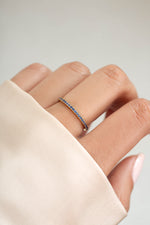 gold sapphire birthstone eternity ring on womens hand