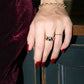 Closeup of gold celestial star dome rings on model with red nail polish