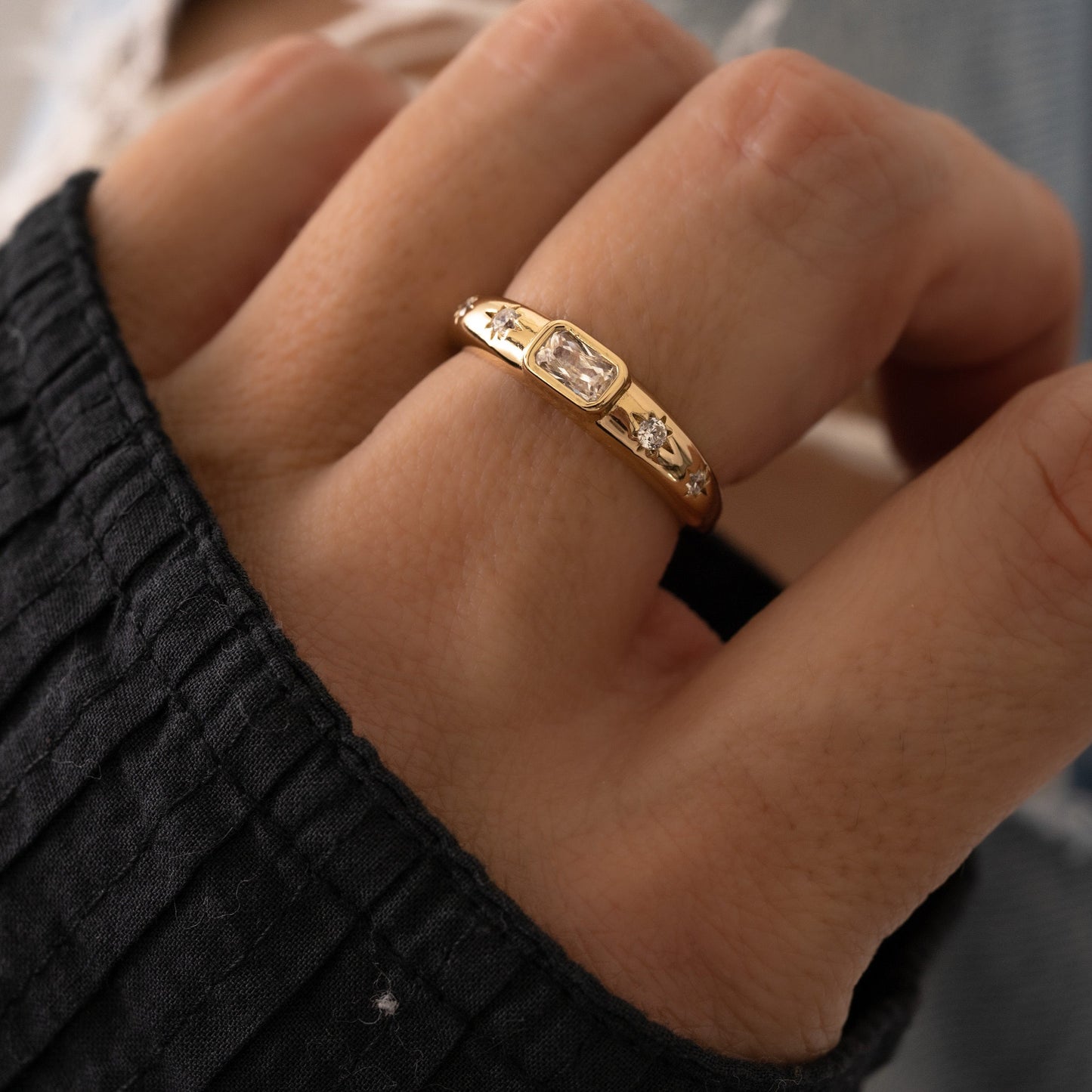 Gold statement ring for women with tiny starburst diamonds and diamond baguette setting, shown on model