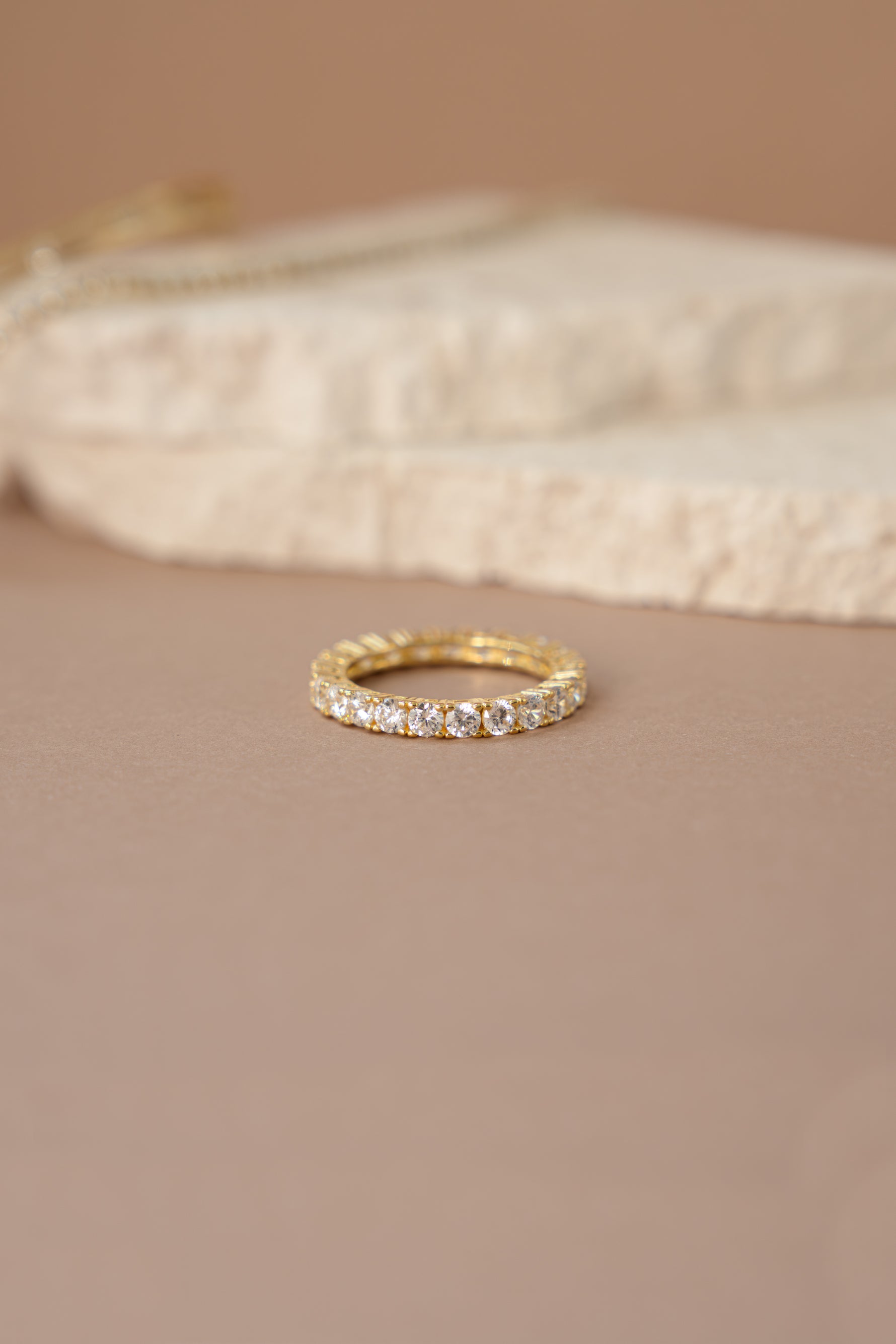 gold studded eternity ring  neutral background