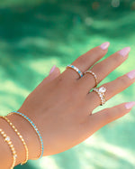 gold turquoise and diamond eternity ring on models hand stacked with gold and turquoise jewelry
