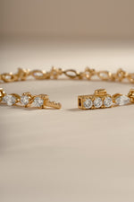 Gold tennis bracelet by Sami Jewels featuring marquise and round cut diamond stones with a secure box clasp.