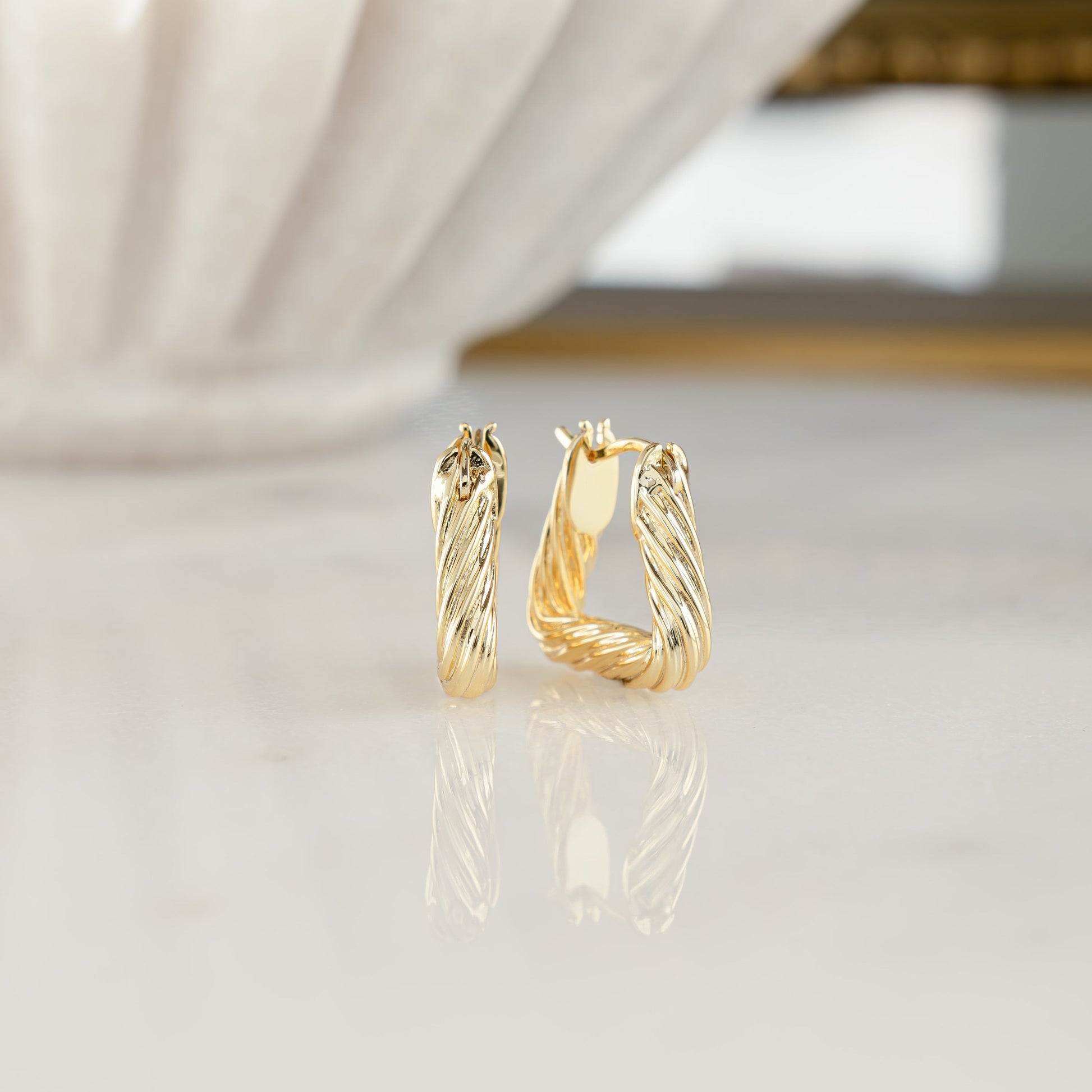 Chunky triangle hoop earrings in 14k gold with a textured pattern. 