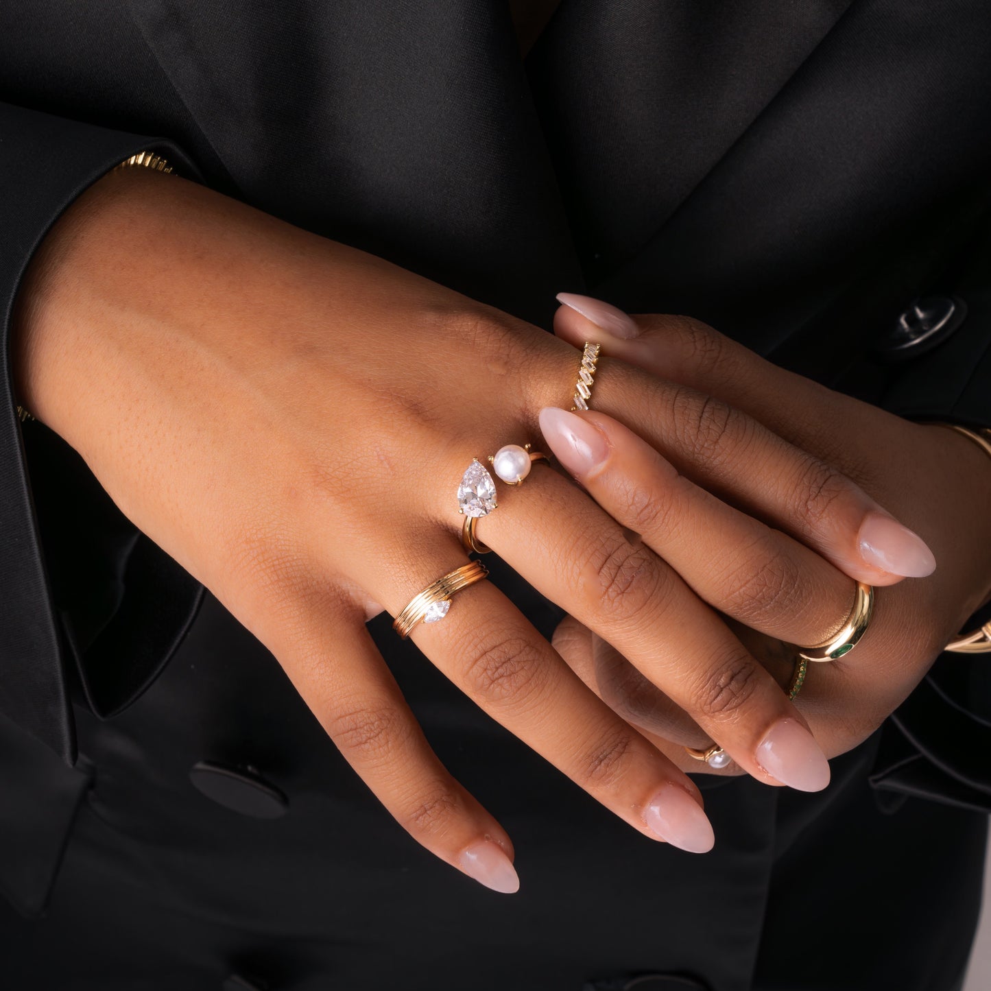 A models hand wearing Toi et Moi Ring in gold on her middle finger, paired with gold rings on her index and ring fingers, demonstrating the versatility of this ring as both a statement ring and promise ring for everyday wear.