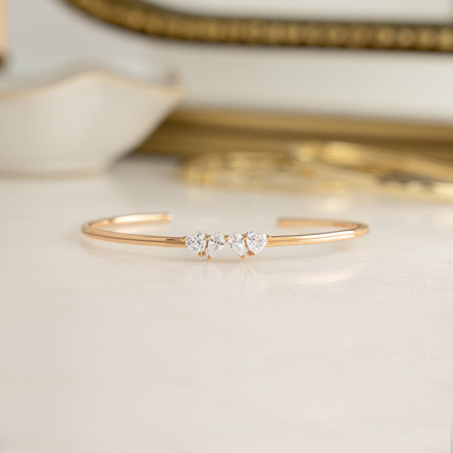 a dainty gold bangle bracelet that is adjustable with diamond stones