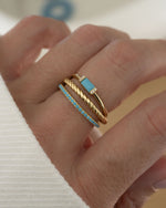 gold turquoise rings stacked on womens hand