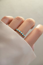 gold turquoise and opal stacking ring on womens hand