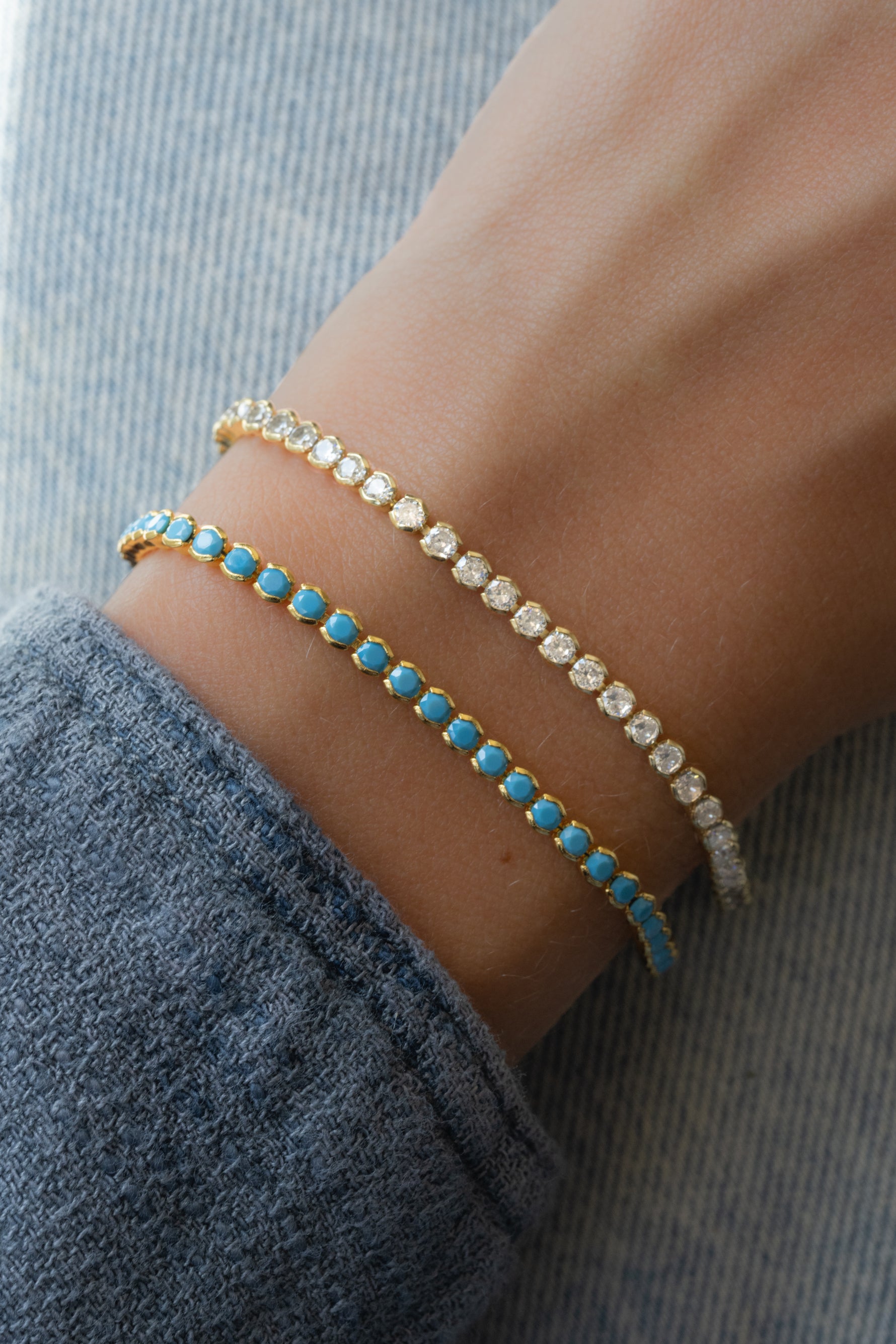 gold turquoise tennis bracelet and gold diamond tennis bracelet on models wrist