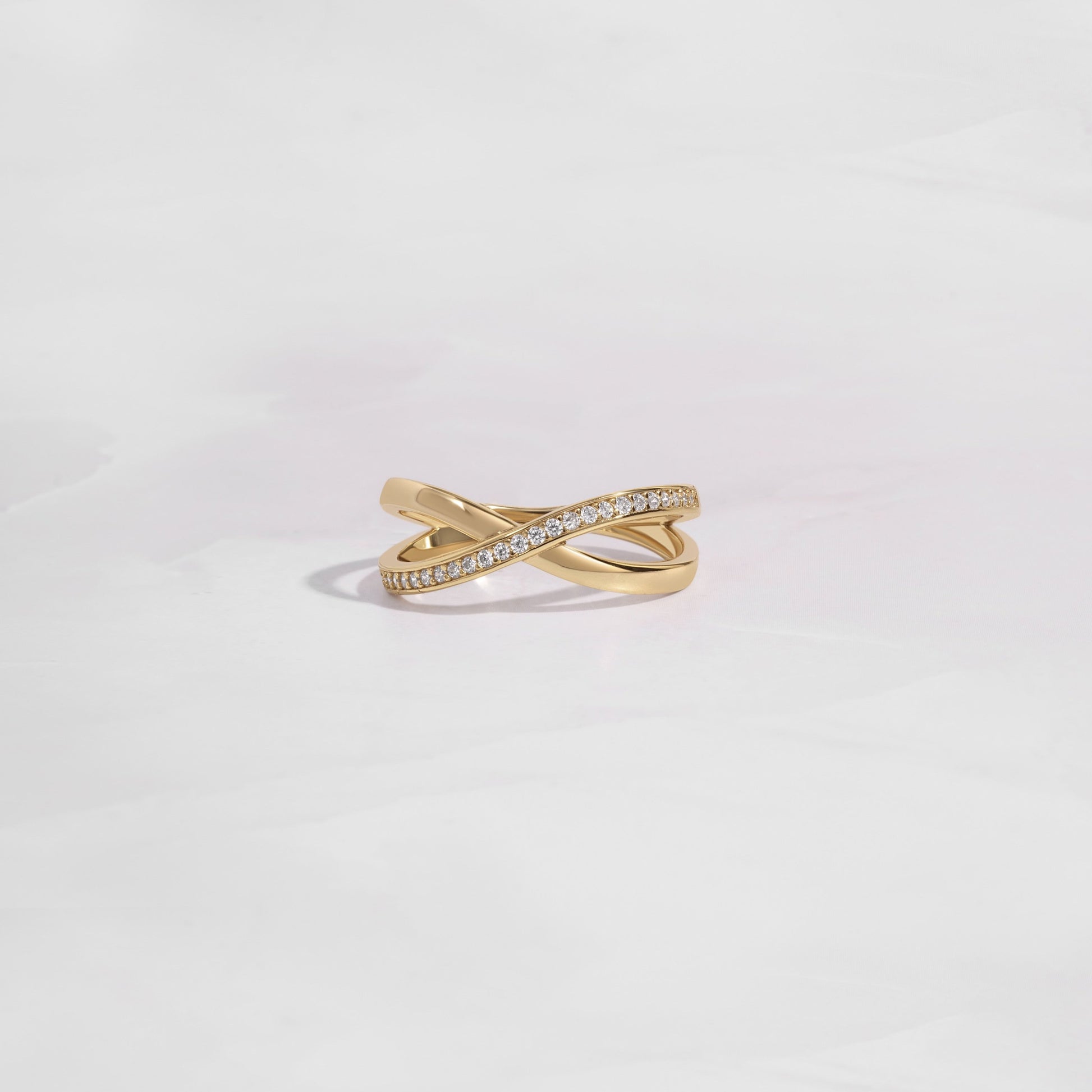 close up of gold wedding band with an X design