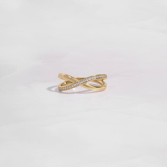 close up of gold wedding band with an X design