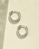 Silver stainless steel half-textured huggie hoop earrings by Sami Jewels, showing close-up of sleek, modern jewelry design.
