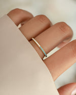 Half of a gold eternity ring featuring turquoise and diamond accents, showcasing intricate jewelry design by Sami Jewels.