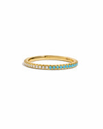 Dainty Sami Jewels gold eternity ring with turquoise and diamond accents, showcasing intricate design on a white background.