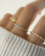 Sami Jewels turquoise and diamond eternity ring stacked on a gold band, showcasing a half-turquoise and diamond design.