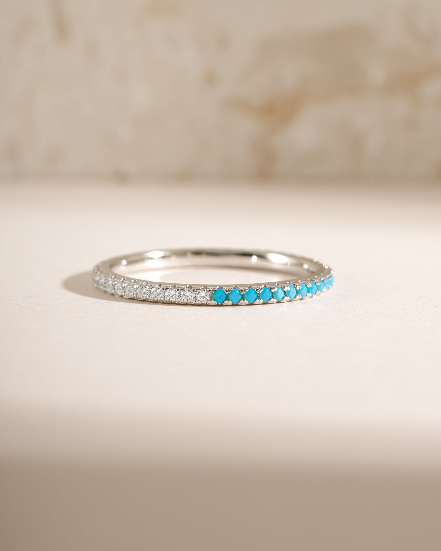 Sterling silver eternity ring by Sami Jewels featuring turquoise and diamond accents in a front view.