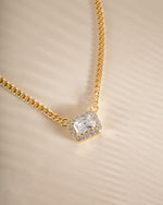 Close-up of Sami Jewels Halo Emerald Cut Necklace on a gold Cuban chain, showcasing the elegant emerald-cut pendant.