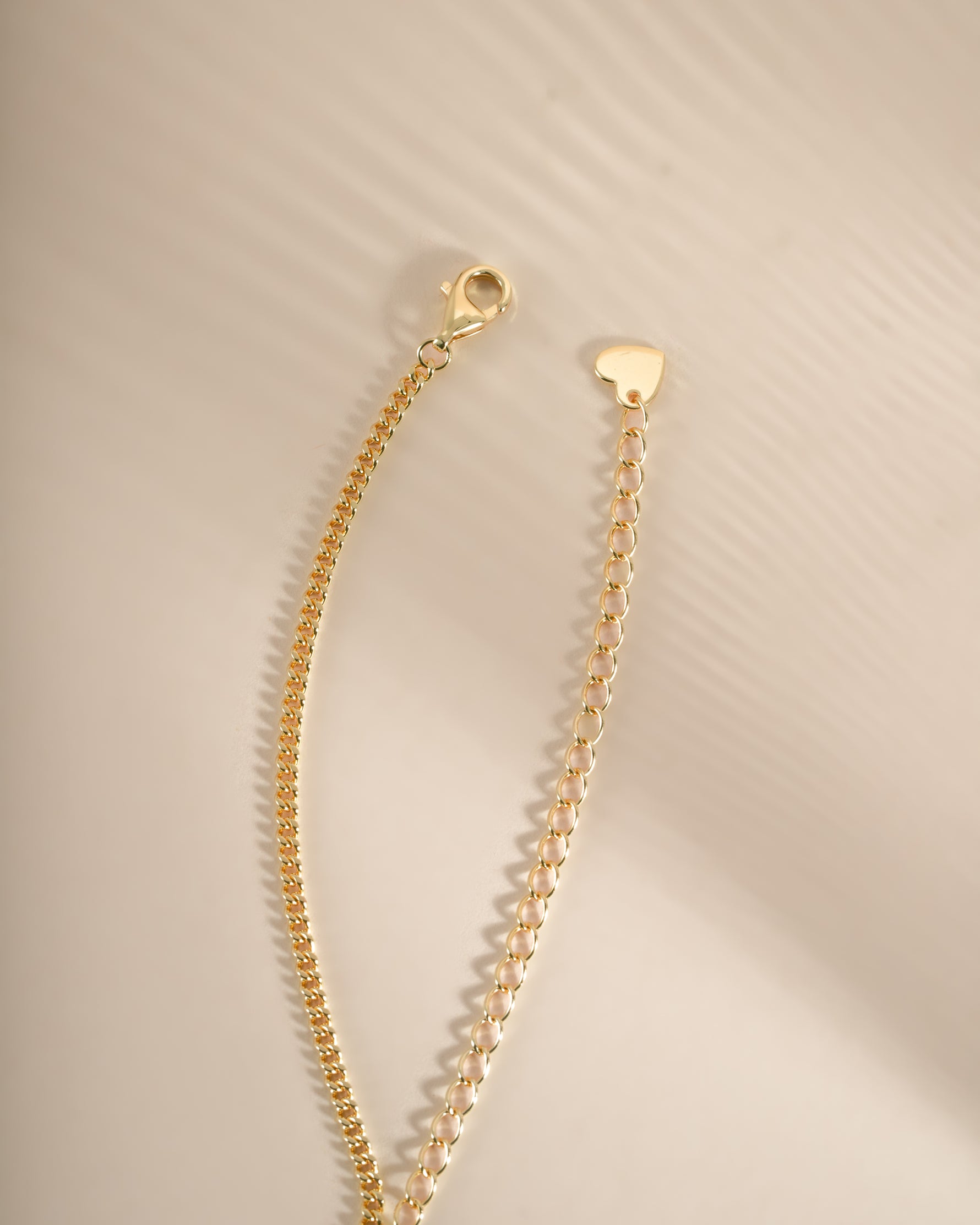 Gold Halo Emerald Cut Necklace on Cuban Chain with lobster clasp by Sami Jewels, showcasing a sparkling emerald-cut pendant.