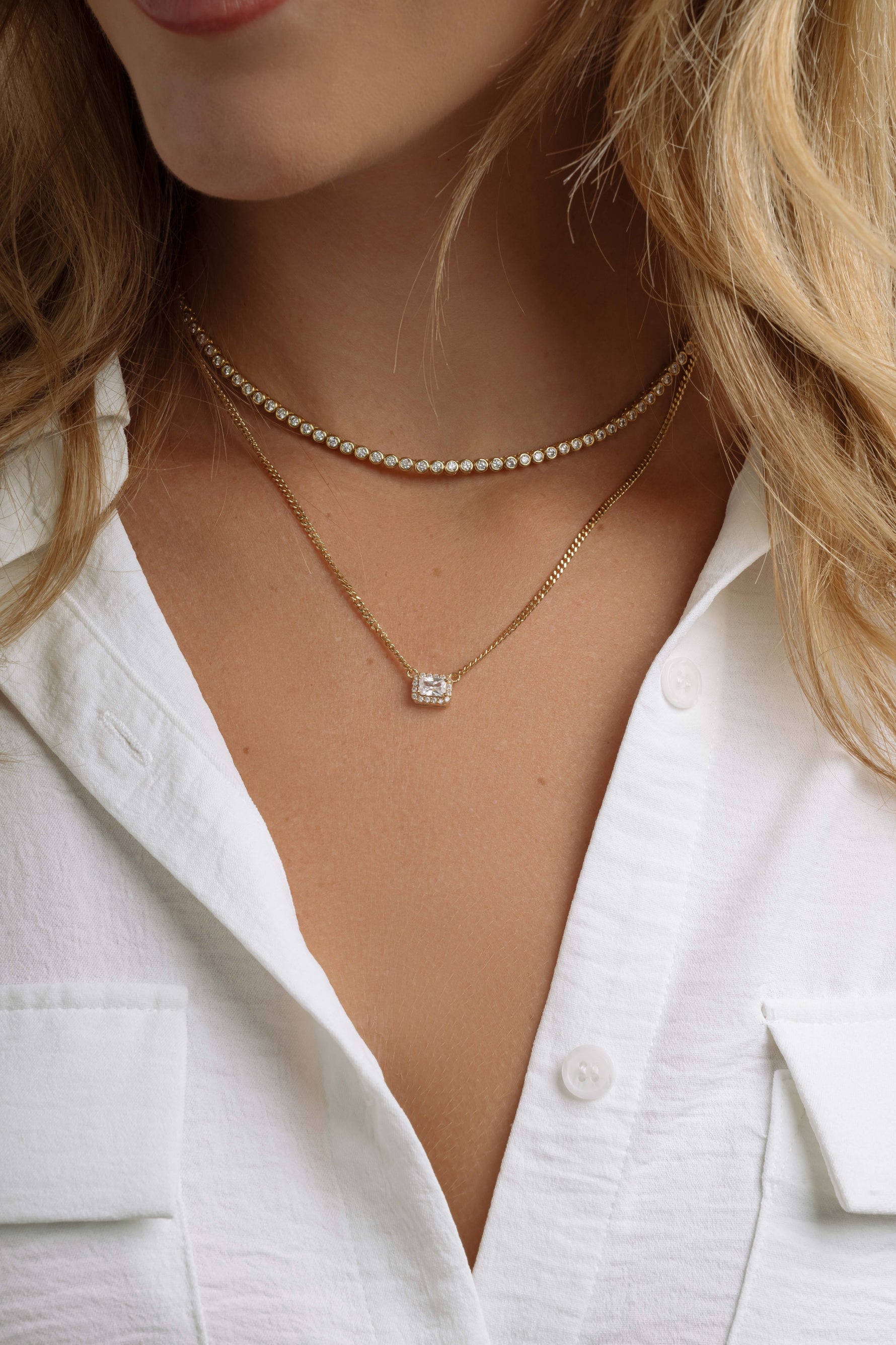 Gold halo emerald cut necklace on Cuban chain, worn by a model, showcasing elegant jewelry design by Sami Jewels.