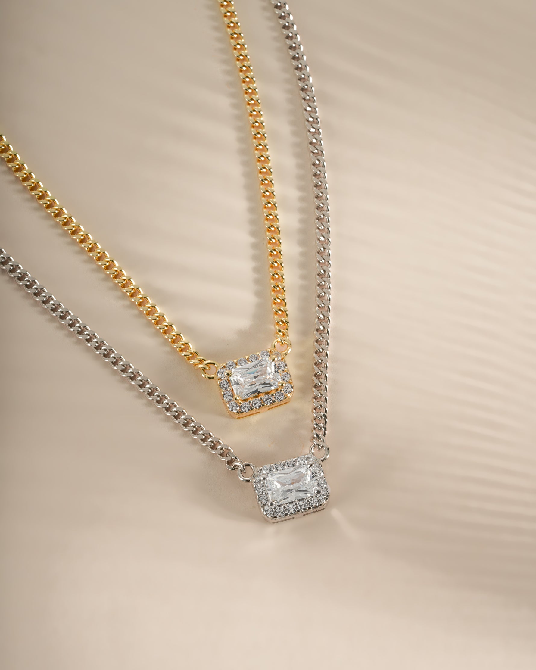Sterling silver and gold Halo Emerald Cut Necklace on a Cuban chain by Sami Jewels, showcasing a sparkling emerald-shaped pendant.