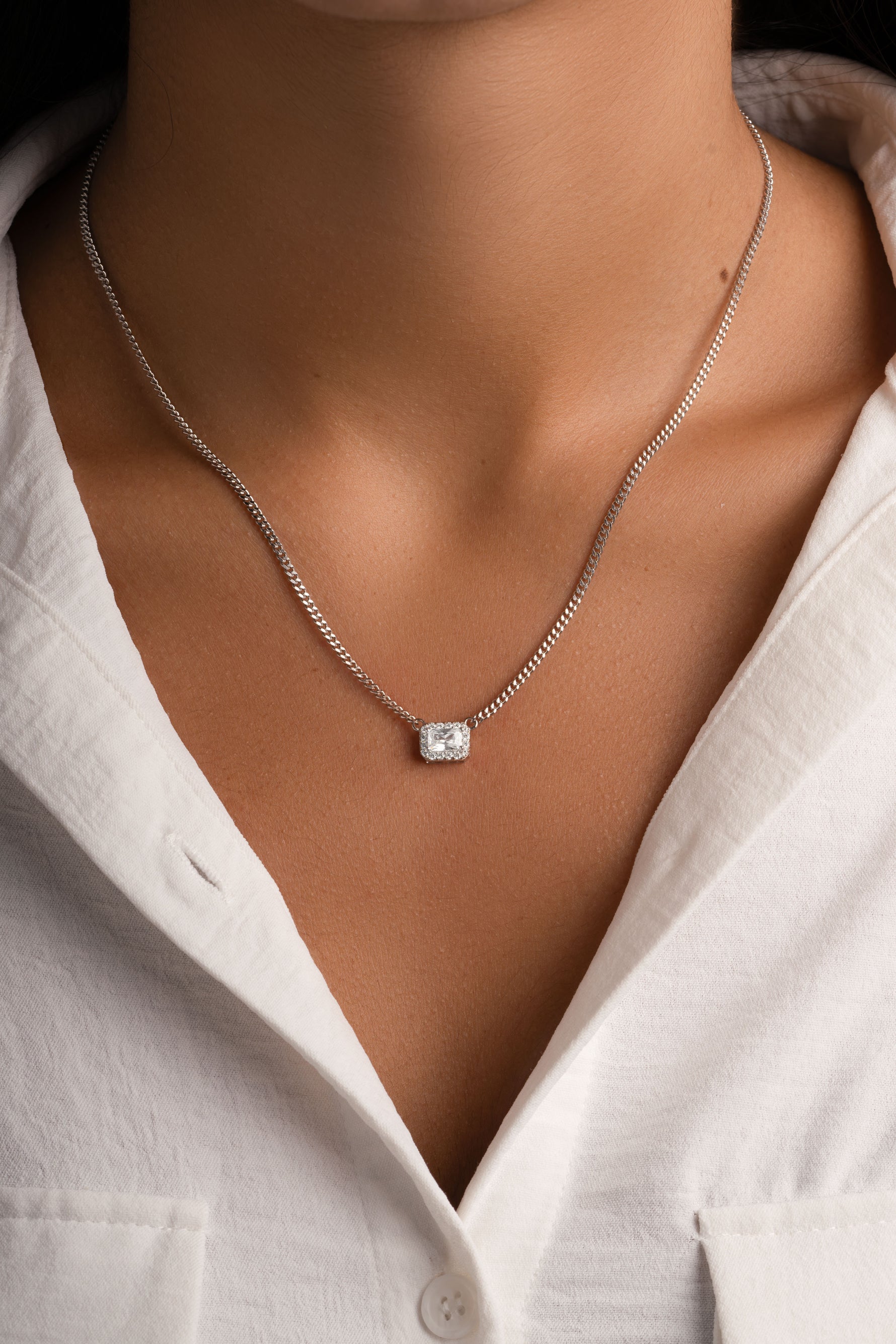 Sterling silver Halo Emerald Cut Necklace on a Cuban chain by Sami Jewels, featuring a striking emerald-cut pendant.