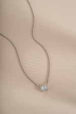 Sterling silver halo emerald cut necklace on a Cuban chain, featuring a sparkling center gemstone and intricate chain design