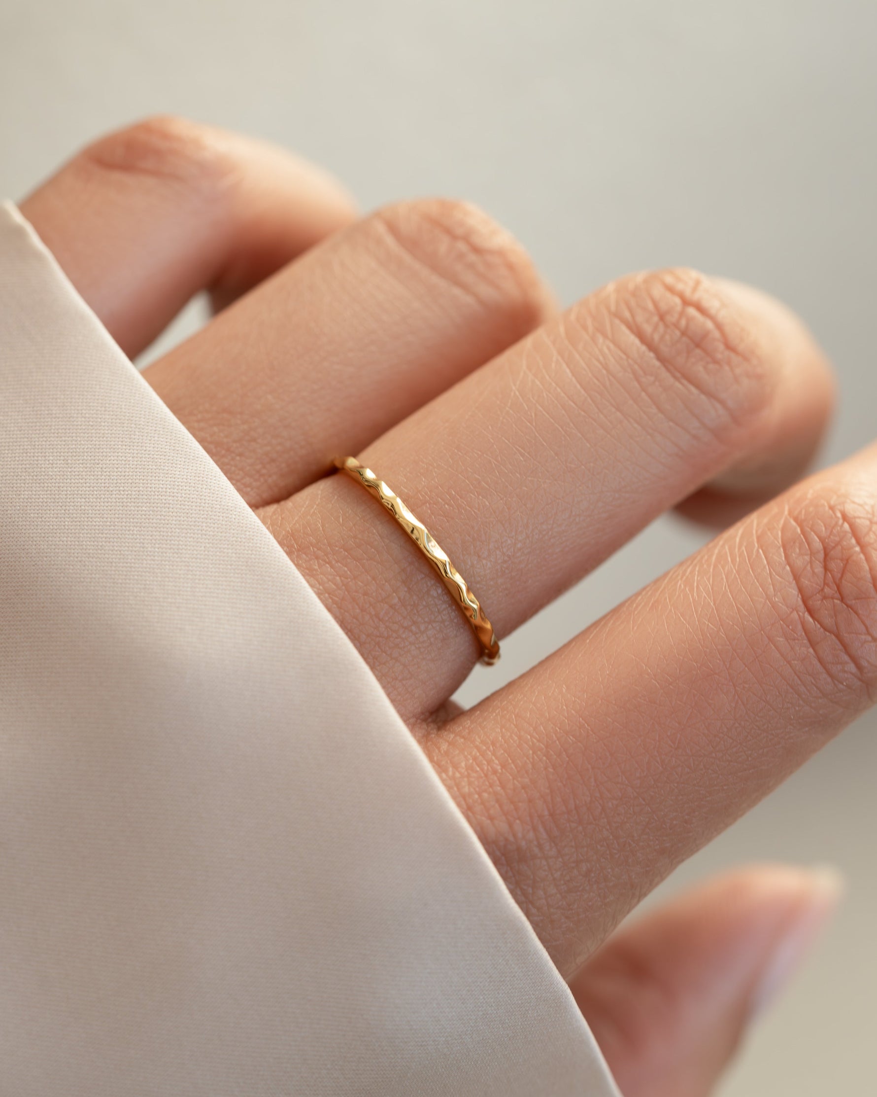 Gold hammered stacking ring by Sami Jewels worn on a model's finger, showcasing its textured finish and stylish design.