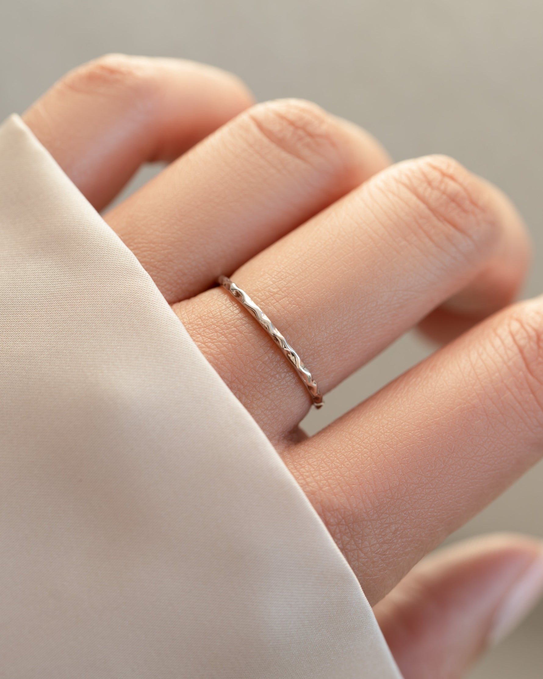 Sterling silver hammered stacking ring by Sami Jewels worn on a model's finger, showcasing its textured finish and stylish design.
