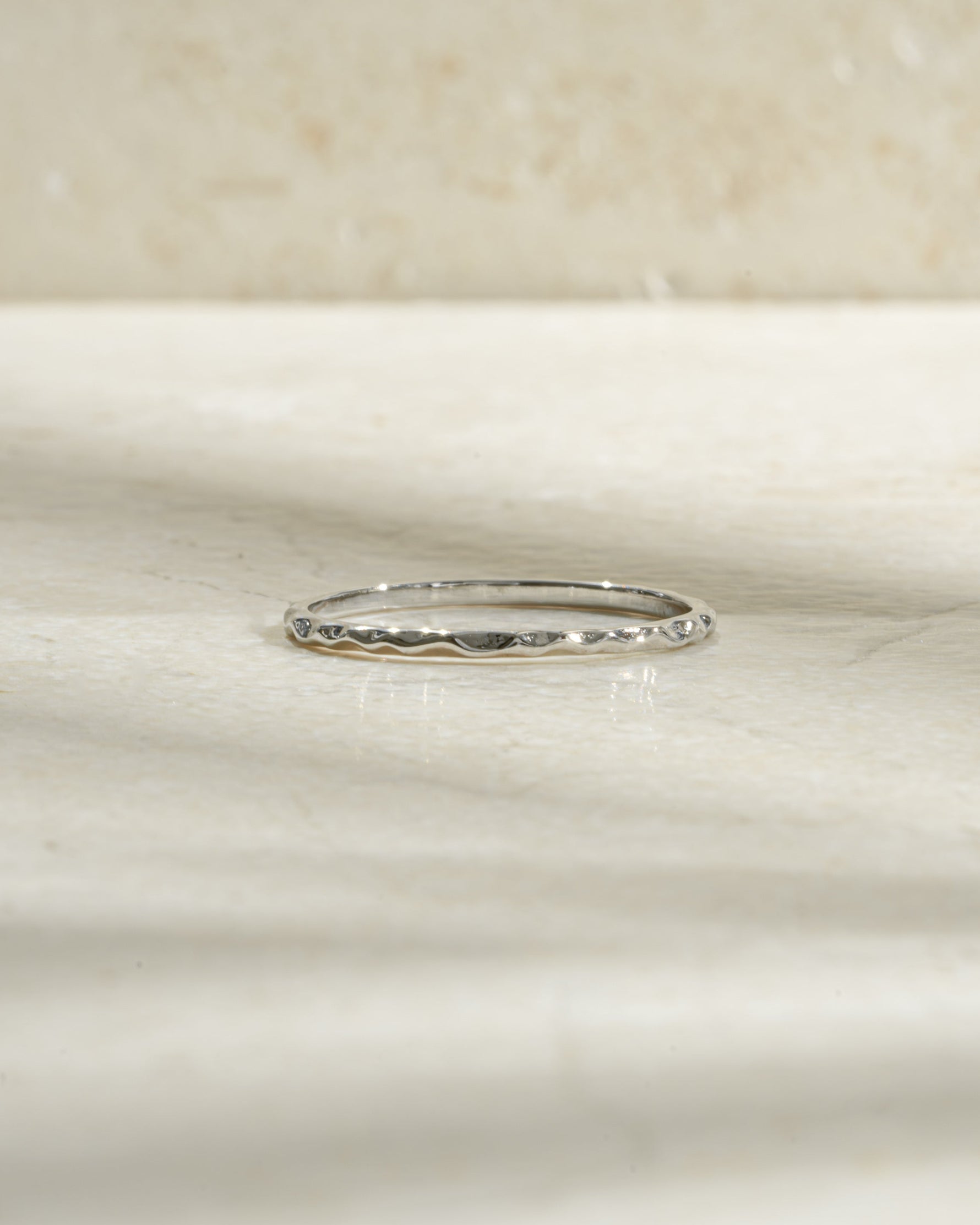 Sterling silver hammered stacking ring from Sami Jewels with a textured, shiny surface, designed for versatile layered jewelry.