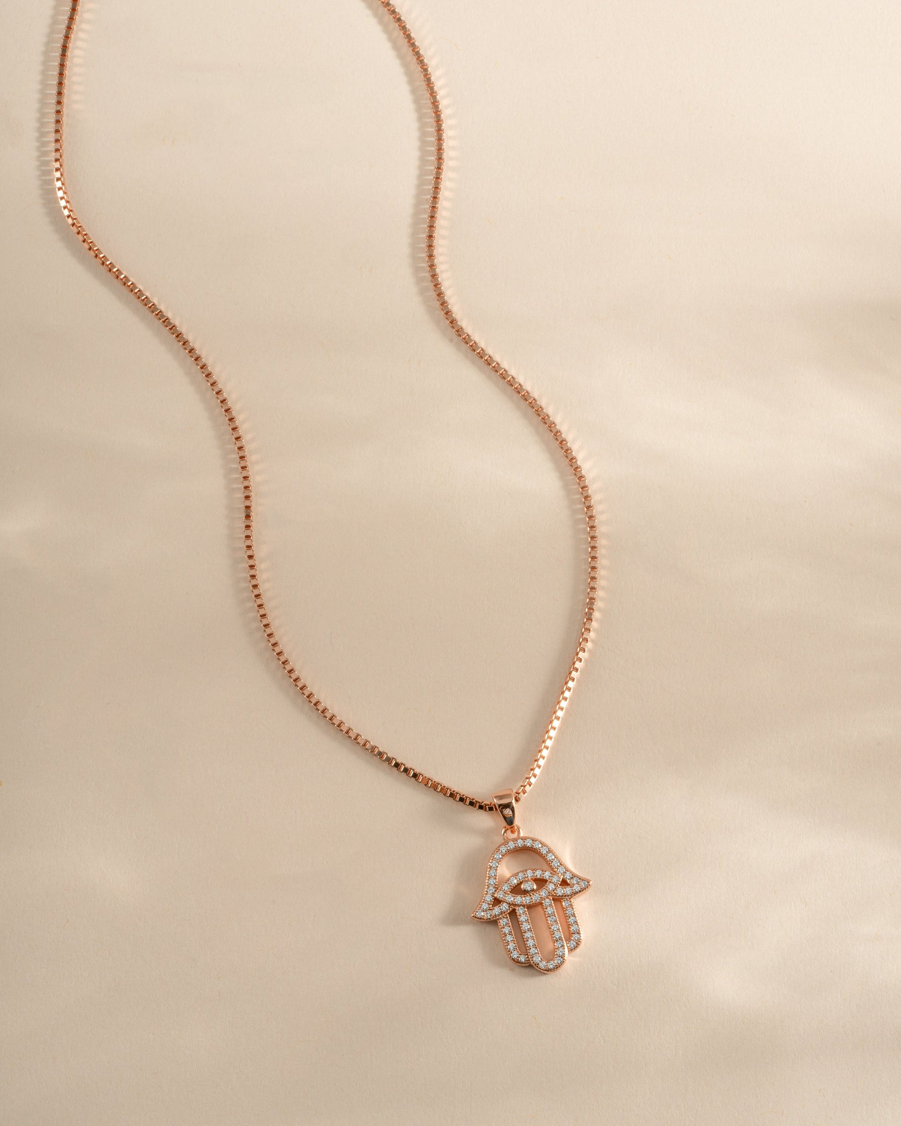 Rose gold Hamsa necklace from Sami Jewels featuring intricate design and a protective charm, front view of the jewelry piece.