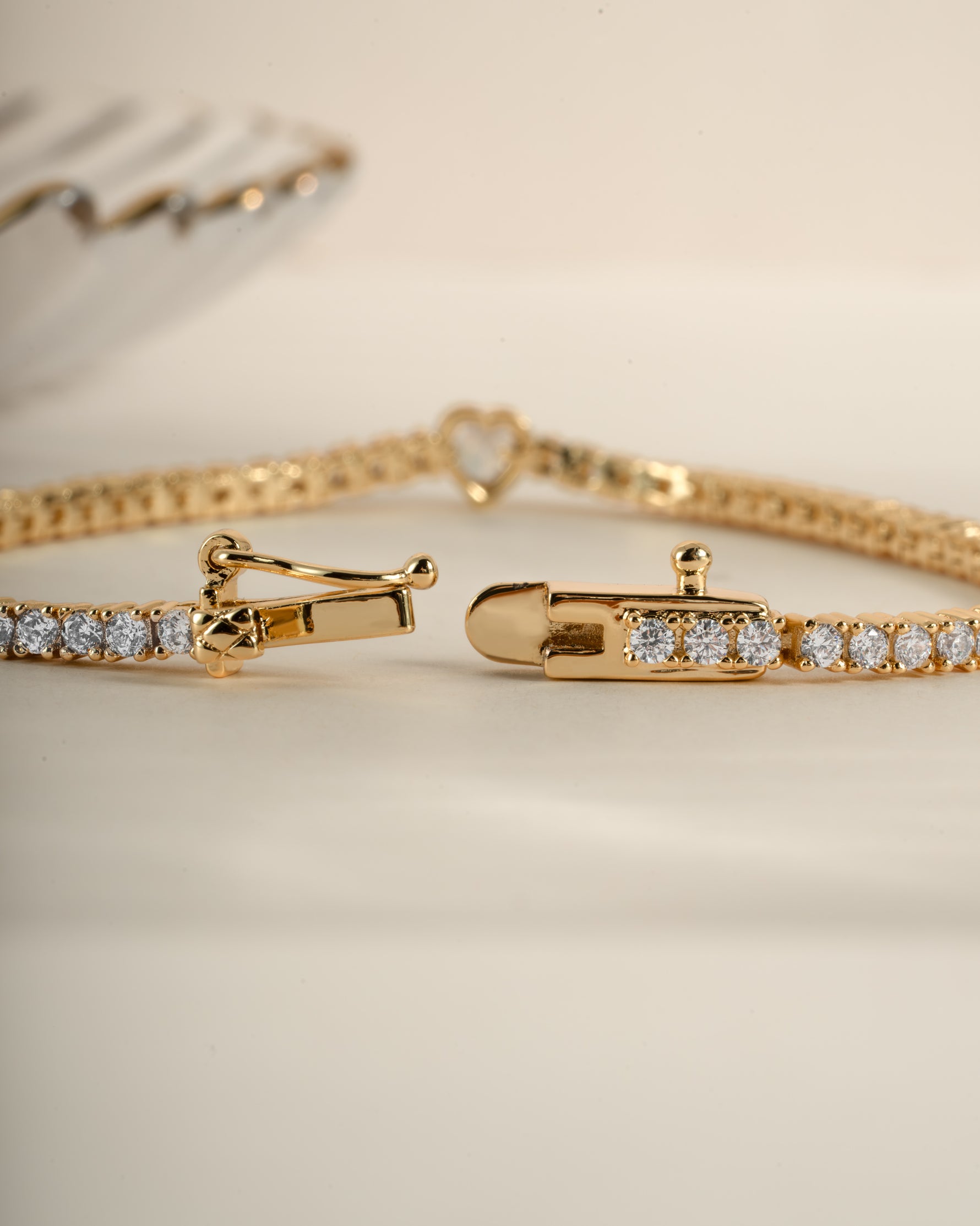 Gold Heart Charm Tennis Bracelet by Sami Jewels featuring a box clasp closure and delicate heart-shaped charms.