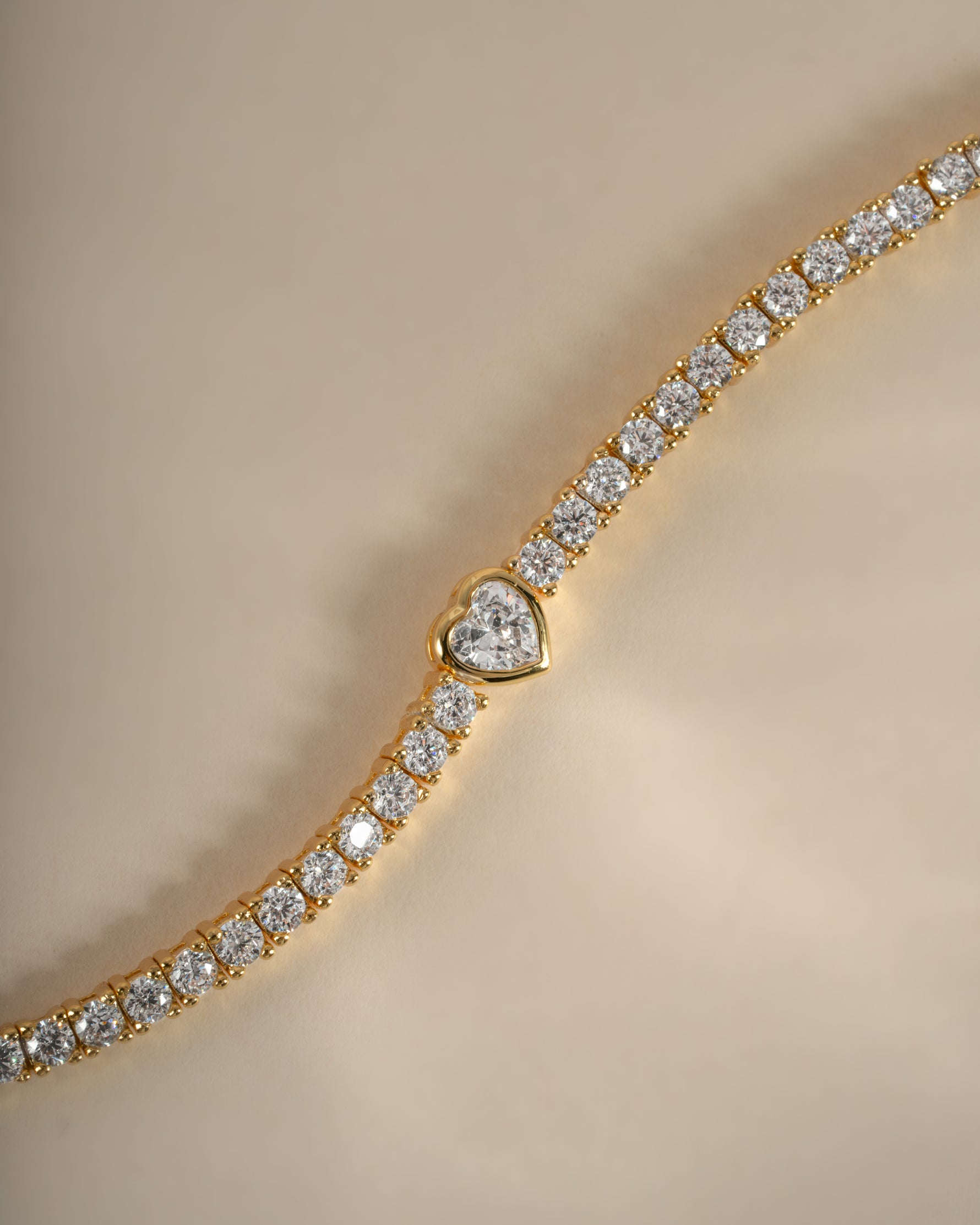 Close-up of Sami Jewels Heart Charm Tennis Bracelet in gold, showcasing the delicate heart-shaped charms on a sleek tennis bracelet.