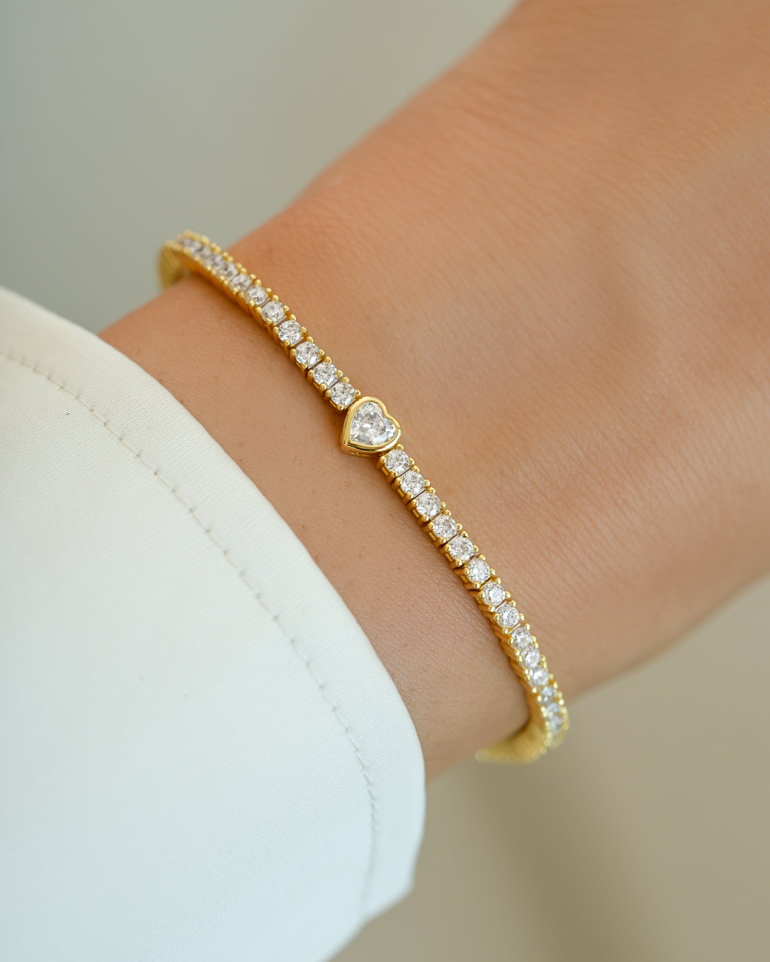 Gold Sami Jewels heart charm tennis bracelet with delicate chain and sparkling heart pendants, elegant jewelry accessory.