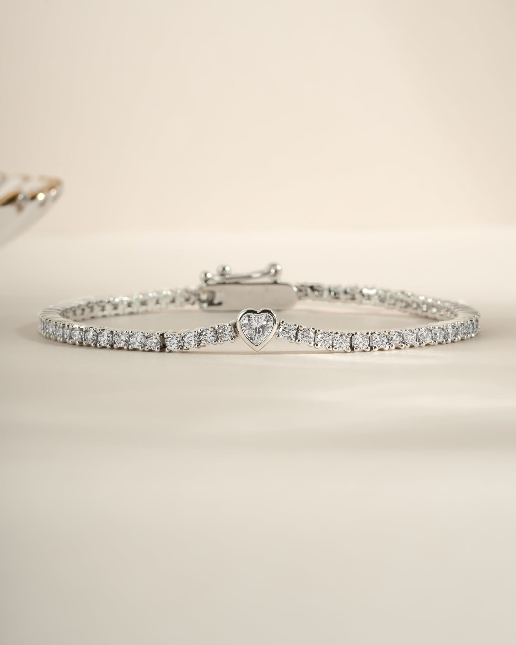 Silver heart charm tennis bracelet by Sami Jewels featuring a delicate chain and elegant heart-shaped charms.