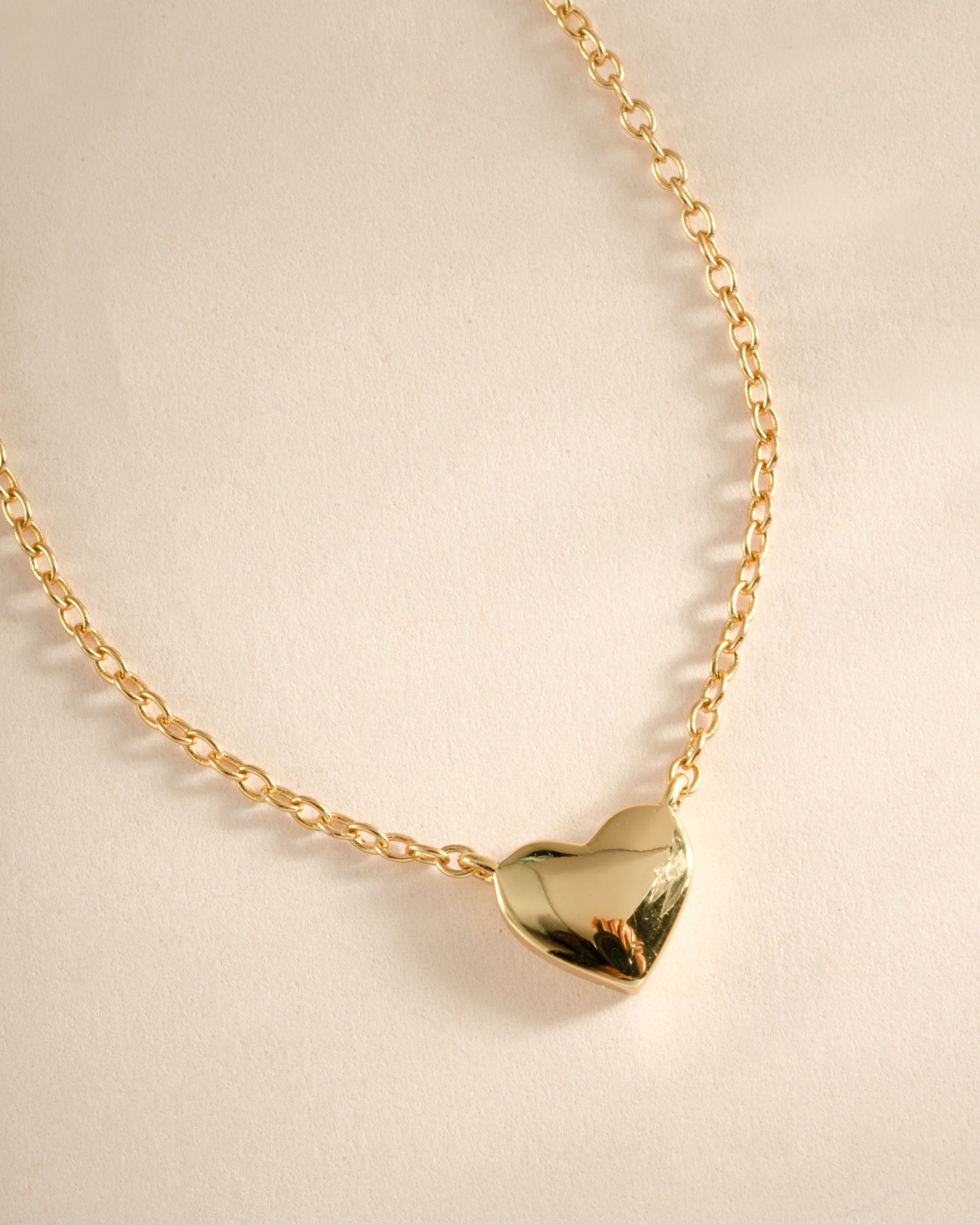 Close-up of a gold heart necklace from Sami Jewels, featuring a delicate pendant on a fine chain.