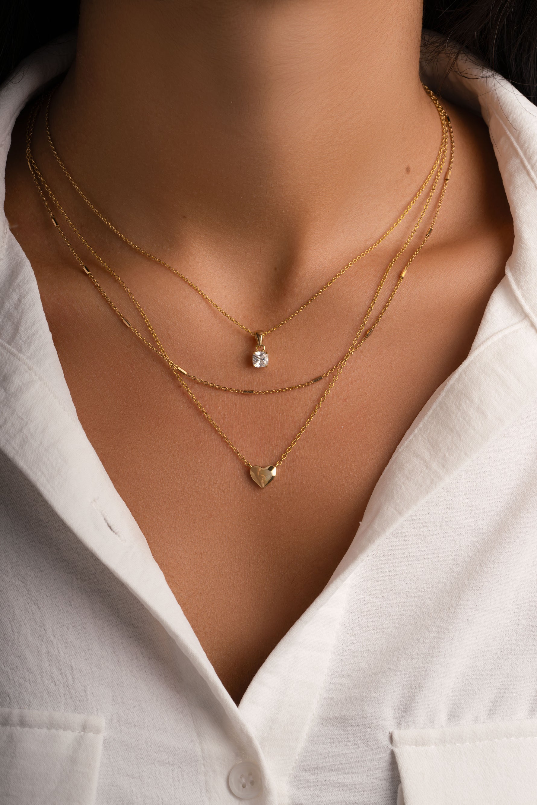 Gold heart necklace by Sami Jewels worn on a model, showcasing a stylish and elegant jewelry piece.