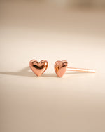 Rose gold heart stud earrings by Sami Jewels, front view showing delicate heart shape and shiny finish.