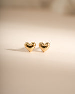 Gold heart-shaped stud earrings by Sami Jewels, front view showcasing elegant design and shiny finish.