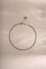 Sterling silver 2mm herringbone bracelet from Sami Jewels displayed flat, showing its sleek, flat chain design.