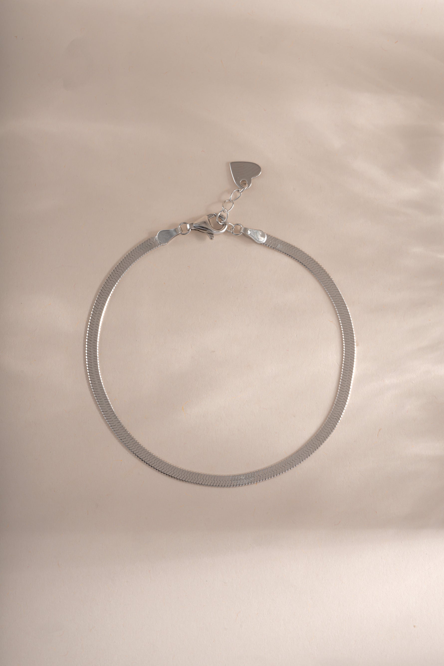 Sterling silver 2mm herringbone bracelet from Sami Jewels displayed flat, showing its sleek, flat chain design.