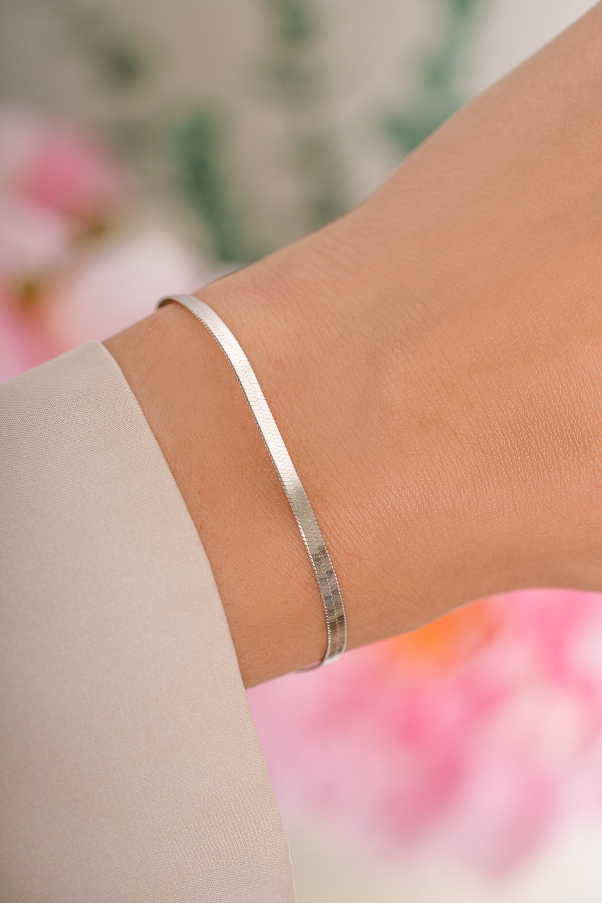 Sterling silver 2mm herringbone bracelet from Sami Jewels featuring a sleek, woven chain design on a model.