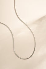 Silver 2mm herringbone chain necklace by Sami Jewels, showcasing sleek, flat linked design on a white background.