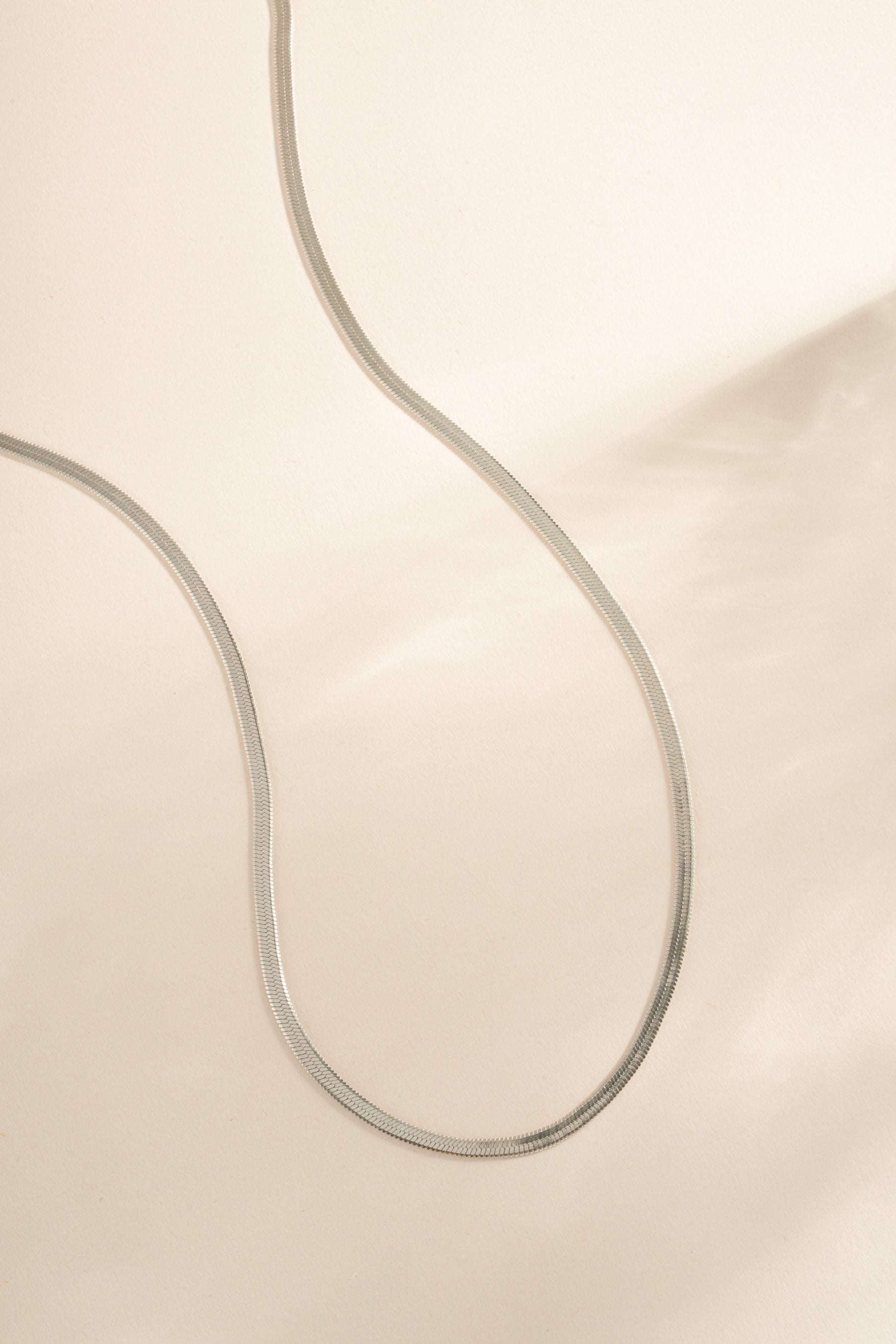 Silver 2mm herringbone chain necklace by Sami Jewels, showcasing sleek, flat linked design on a white background.