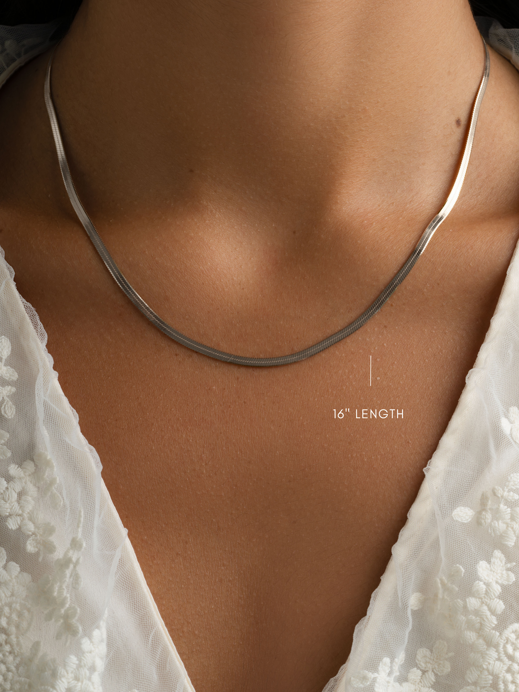Sterling silver 2mm herringbone chain necklace by Sami Jewels, close-up view showing smooth, flexible design on a model.
