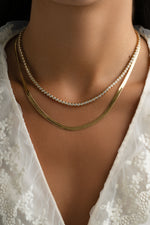 Gold 4mm herringbone necklace by Sami Jewels featuring a sleek, flat woven chain design on a neutral background.