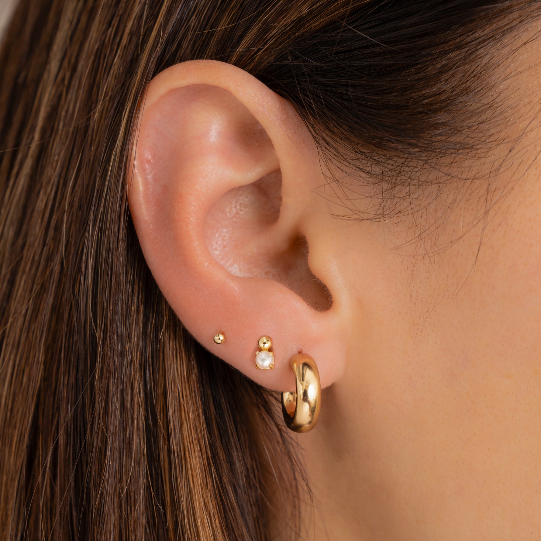 chunky gold hoop everyday hoop earrings paired with pearl studs