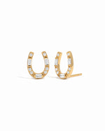 A pair of gold horseshoe-shaped stud earrings embellished with small clear baguette and round-cut stones, shown on a plain white background.