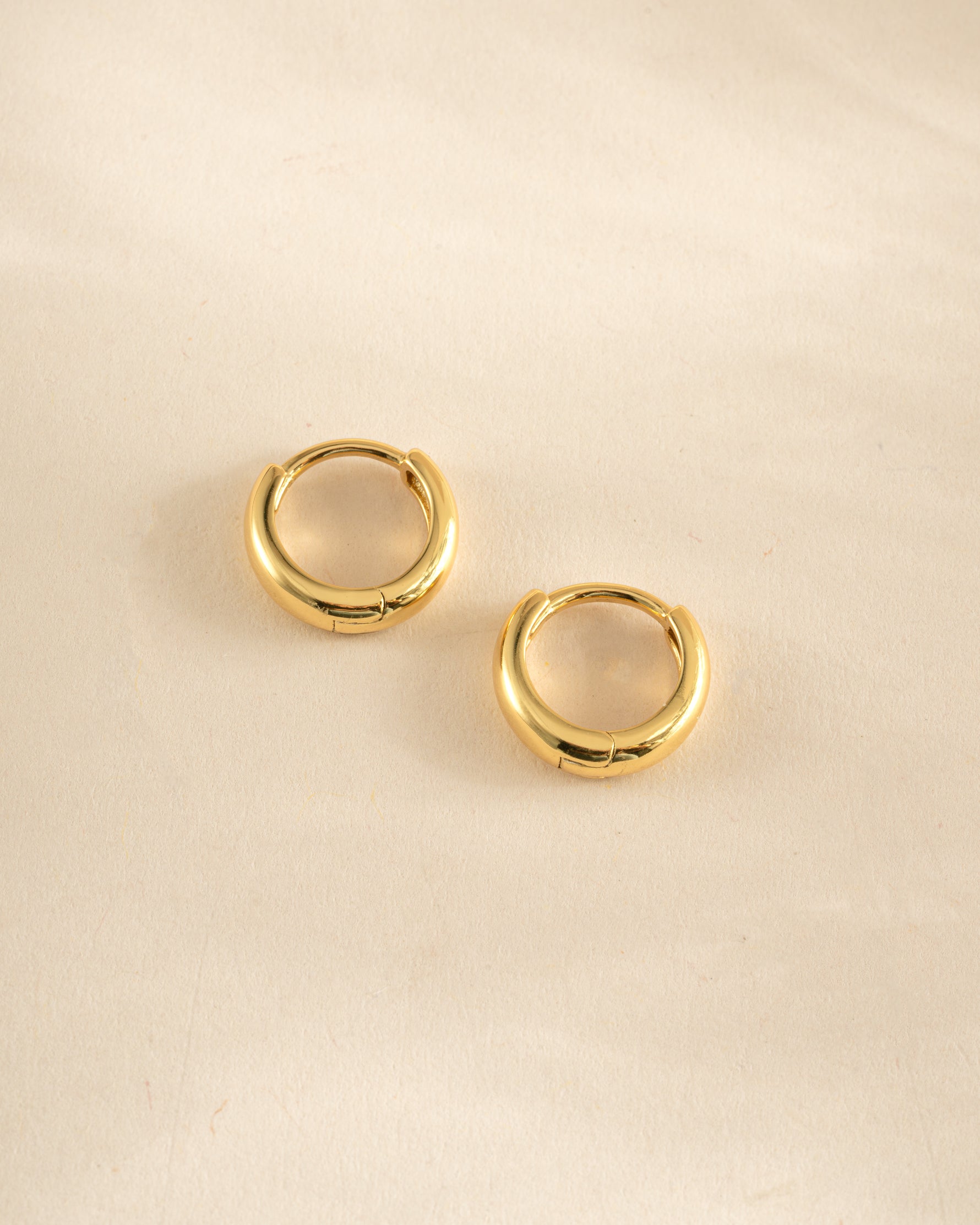 Gold minimalist huggie hoop earrings by Sami Jewels, side profile view showing sleek, simple design.